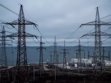 Industrielle Strommasten und Hochspannungsleitungen an der Küste der Ostsee bei Dämmerung als Symbol für kritische Infrastruktur. - Foto: über boerse-global.de