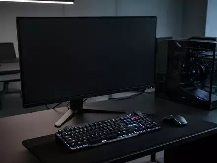 Ein dunkler, moderner Computer-Arbeitsplatz mit einem ausgeschalteten Monitor und einer mechanischen Tastatur. - Foto: über boerse-global.de