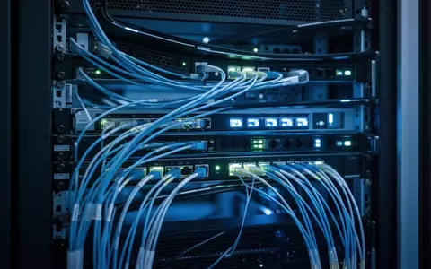 Moderne Serverinfrastruktur mit blau beleuchteten Glasfaserkabeln und technischer Hardware in einem Rechenzentrum. - Foto: über boerse-global.de