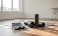 Ein heller, minimalistischer Physiotherapieraum mit Trainingsschuhen und einer Yogamatte im Sonnenlicht. - Foto: über boerse-global.de
