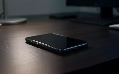 Ein unbenutztes Smartphone liegt auf einem dunklen Büroschreibtisch, symbolisch für digitale Sicherheitsrisiken. - Foto: über boerse-global.de