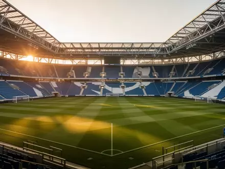 Ein leeres Fußballstadion in Nordrhein-Westfalen bei Sonnenuntergang mit Blick auf das gepflegte Spielfeld. - Foto: über boerse-global.de