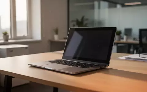 Ein moderner, aufgeräumter Schreibtisch mit einem zugeklappten Laptop in einer professionellen Büroumgebung. - Foto: über boerse-global.de
