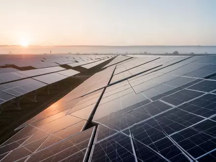 Moderne Solarpark-Anlage bei Sonnenaufgang mit Reihen von Photovoltaik-Modulen. - Foto: über boerse-global.de