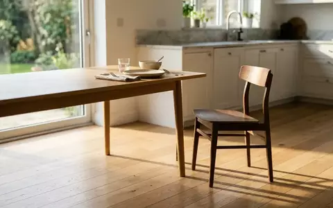 Ein einsamer Stuhl an einem gedeckten Tisch in einem hellen, modernen Esszimmer. - Foto: über boerse-global.de