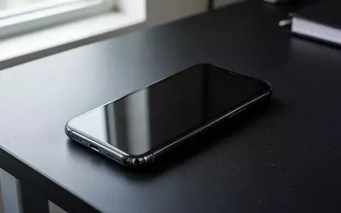 Ein Smartphone liegt mit dem dunklen Display nach unten auf einem Schreibtisch als Symbol für Cybersicherheit und Phishing-Gefahren. - Foto: über boerse-global.de