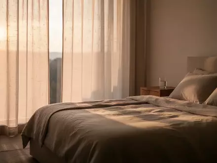 Ein minimalistisch eingerichtetes Schlafzimmer bei Tagesanbruch mit weichem Morgenlicht und einem unberührten Bett. - Foto: über boerse-global.de