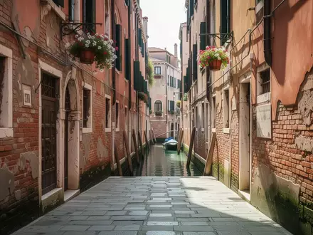Eine leere, schmale Gasse in Venedig bei Tageslicht mit historischen Backsteinfassaden und Blick auf einen Kanal. - Foto: über boerse-global.de