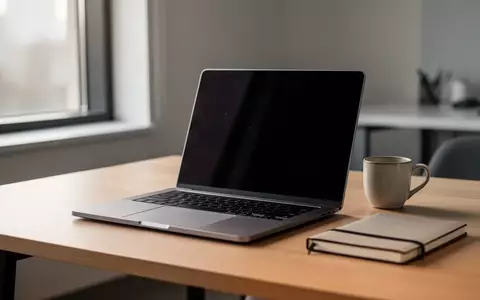 Ein moderner, aufgeräumter Arbeitsplatz mit einem Laptop, einer Kaffeetasse und einem Notizbuch auf einem Holztisch. - Foto: über boerse-global.de