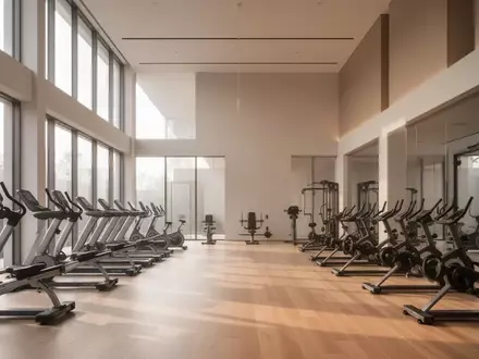 Modernes Fitnessstudio mit minimalistischer Einrichtung und natürlichem Lichteinfall durch große Fensterfronten. - Foto: über boerse-global.de