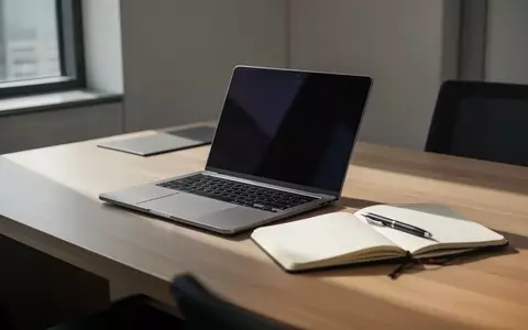 Ein minimalistischer Arbeitsplatz mit einem Laptop mit dunklem Bildschirm und einem Notizbuch in einer hellen Büroumgebung. - Foto: über boerse-global.de