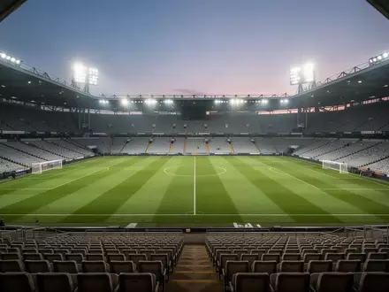 Ein leeres Fußballstadion bei Flutlicht am Abend mit Blick auf den grünen Rasen. - Foto: über boerse-global.de