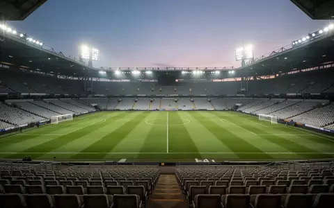 Ein leeres Fußballstadion bei Flutlicht am Abend mit Blick auf den grünen Rasen. - Foto: über boerse-global.de