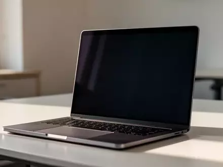 Ein moderner, zugeklappter Laptop auf einem minimalistischen Schreibtisch bei natürlichem Licht. - Foto: über boerse-global.de