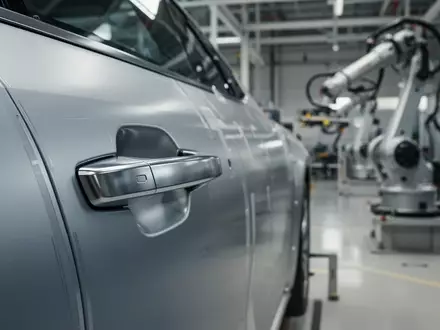 Moderner Türgriff eines Fahrzeugs in einer hochmodernen Produktionsanlage für Automobiltechnologie. - Foto: über boerse-global.de