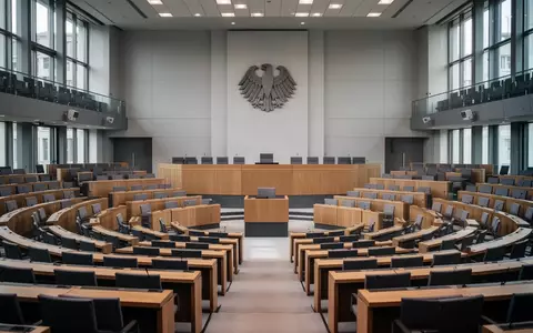 Der leere Plenarsaal des Deutschen Bundestages mit Blick auf die Sitzreihen und das Bundesadler-Emblem. - Foto: über boerse-global.de