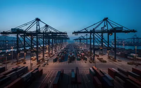 Moderne Hafenanlage mit Containerbrücken bei Dämmerung als Symbol für die maritime Lieferketteninfrastruktur. - Foto: über boerse-global.de