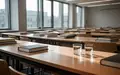 Ein leerer, modern gestalteter Hörsaal mit ordentlichen Schreibtischen und Lehrbüchern in einer ruhigen Lernumgebung. - Foto: über boerse-global.de