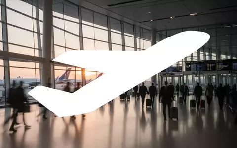 Moderne Flughafenarchitektur mit einfallendem Morgenlicht und verschwommenen Passagier-Silhouetten. - Foto: über boerse-global.de