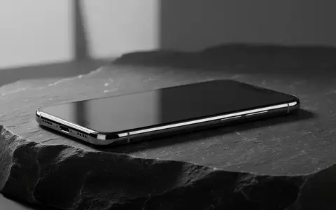 Ein modernes Smartphone auf einer dunklen Steinoberfläche in einem minimalistischen, professionellen Studio-Setup. - Foto: über boerse-global.de