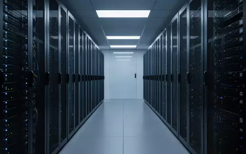 Moderne Serverräume mit Reihen dunkler Server-Racks in kühlem, blauem Licht als Symbol für KI-Infrastruktur. - Foto: über boerse-global.de
