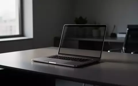 Ein minimalistischer, moderner Schreibtisch mit einem zugeklappten, metallischen Laptop in einem Büro bei natürlichem Licht. - Foto: über boerse-global.de