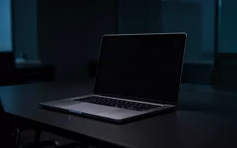Ein dunkler, moderner Arbeitsplatz mit einem Laptop, dessen Bildschirm dunkel bleibt, in einer atmosphärischen Umgebung. - Foto: über boerse-global.de