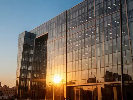 Moderne Glasfassade eines Bürogebäudes in Kairo bei Sonnenuntergang als Symbol für Transparenz und Finanzmärkte. - Foto: über boerse-global.de