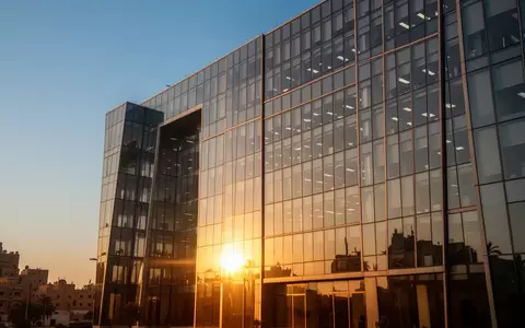Moderne Glasfassade eines Bürogebäudes in Kairo bei Sonnenuntergang als Symbol für Transparenz und Finanzmärkte. - Foto: über boerse-global.de