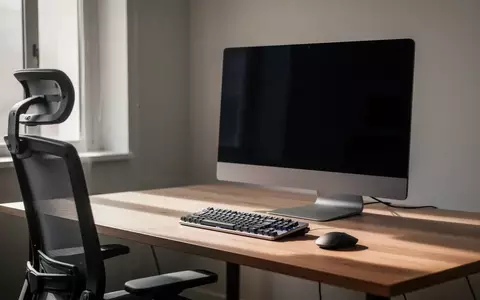 Ein minimalistischer Arbeitsplatz mit einem ausgeschalteten Monitor und einer Tastatur auf einem Holztisch. - Foto: über boerse-global.de