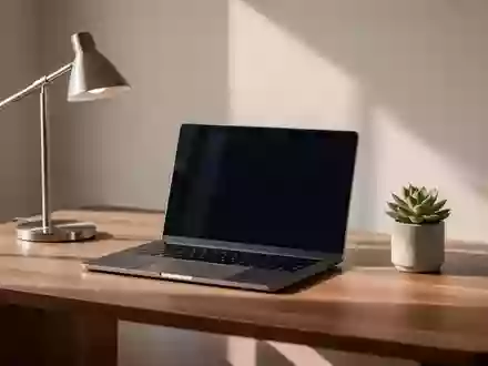 Ein minimalistischer, moderner Arbeitsplatz mit einem Laptop auf einem Schreibtisch bei natürlichem Licht. - Foto: über boerse-global.de