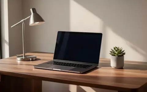 Ein minimalistischer, moderner Arbeitsplatz mit einem Laptop auf einem Schreibtisch bei natürlichem Licht. - Foto: über boerse-global.de