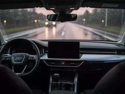 Modernes Autocockpit mit dunklem Infotainment-Display und Blick auf eine regennasse Straße durch die Windschutzscheibe. - Foto: über boerse-global.de