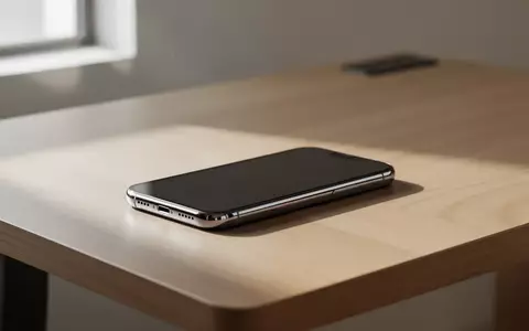 Ein modernes Smartphone liegt auf einem schlichten Holztisch in einem hellen, aufgeräumten Arbeitsbereich. - Foto: über boerse-global.de