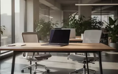 Ein moderner, aufgeräumter Büroarbeitsplatz mit einem Laptop auf einem Holztisch in einer hellen, professionellen Umgebung. - Foto: über boerse-global.de