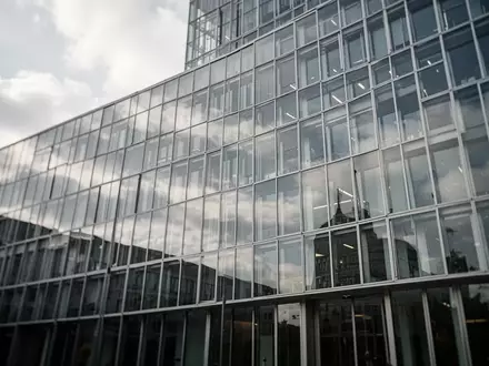 Moderne Glasfassade eines Regierungsgebäudes in Deutschland bei bewölktem Himmel. - Foto: über boerse-global.de