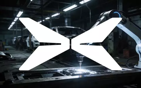 Futuristischer Roboterarm in einer industriellen Fertigungshalle bei kontrastreichem Licht. - Foto: über boerse-global.de