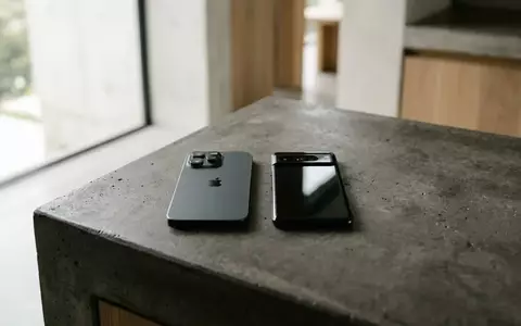 Zwei moderne Smartphones liegen nebeneinander auf einer minimalistischen Betonoberfläche in natürlichem Licht. - Foto: über boerse-global.de