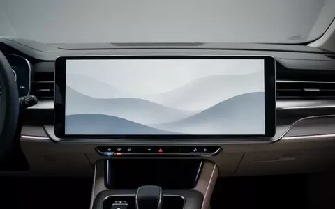 Modernes Infotainment-Display in einem Auto mit abstraktem Wellen-Hintergrund bei gedimmter Beleuchtung. - Foto: über boerse-global.de
