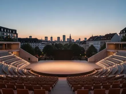 Leeres, modern gestaltetes Amphitheater im Freien bei Dämmerung mit urbaner Kulisse im Hintergrund. - Foto: über boerse-global.de