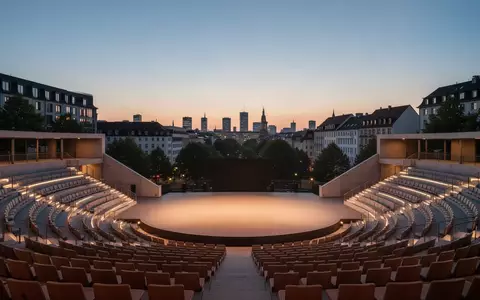 Leeres, modern gestaltetes Amphitheater im Freien bei Dämmerung mit urbaner Kulisse im Hintergrund. - Foto: über boerse-global.de