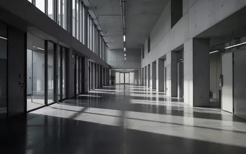 Ein minimalistischer, leerer Flur in einem modernen Regierungsgebäude mit architektonischen Schattenwürfen. - Foto: über boerse-global.de