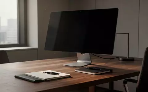 Ein aufgeräumter, moderner Büroarbeitsplatz mit einem ausgeschalteten Computermonitor und einem Notizbuch auf einem Holztisch. - Foto: über boerse-global.de