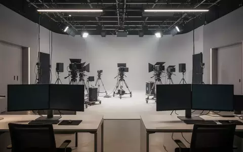Ein minimalistisches, modernes Filmstudio mit professioneller technischer Ausstattung und dunklen Monitoren. - Foto: über boerse-global.de