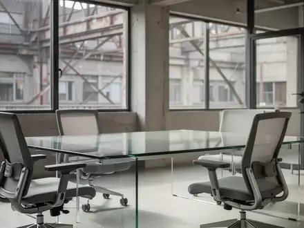 Ein minimalistisch gestalteter, moderner Büroraum mit einem leeren Schreibtisch und natürlichem Tageslicht. - Foto: über boerse-global.de