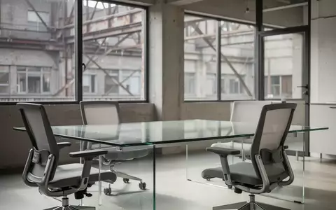 Ein minimalistisch gestalteter, moderner Büroraum mit einem leeren Schreibtisch und natürlichem Tageslicht. - Foto: über boerse-global.de