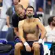 Im fünften Satz wird Novak Djokovic am Rücken behandelt. - Bild: Frank Franklin II/AP/dpa