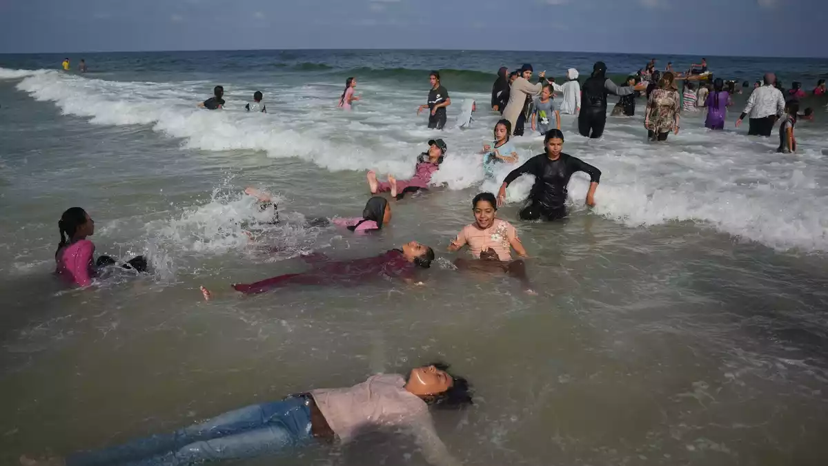 In der aktuellen Sommerhitze bietet das Schwimmen im Meer den Kindern auch Abkühlung.  - Bild: Abdel Kareem Hana/AP/dpa