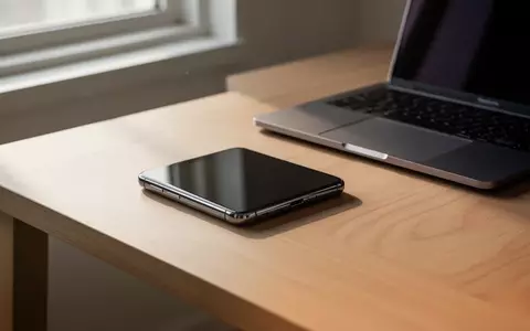 Ein modernes Smartphone auf einem minimalistischen Schreibtisch neben einem Laptop in einer hellen, professionellen Umgebung. - Foto: über boerse-global.de