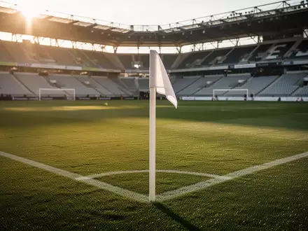 Ein leeres Fußballstadion in Linz bei Sonnenuntergang mit Fokus auf das gepflegte Spielfeld und die Eckfahne. - Foto: über boerse-global.de
